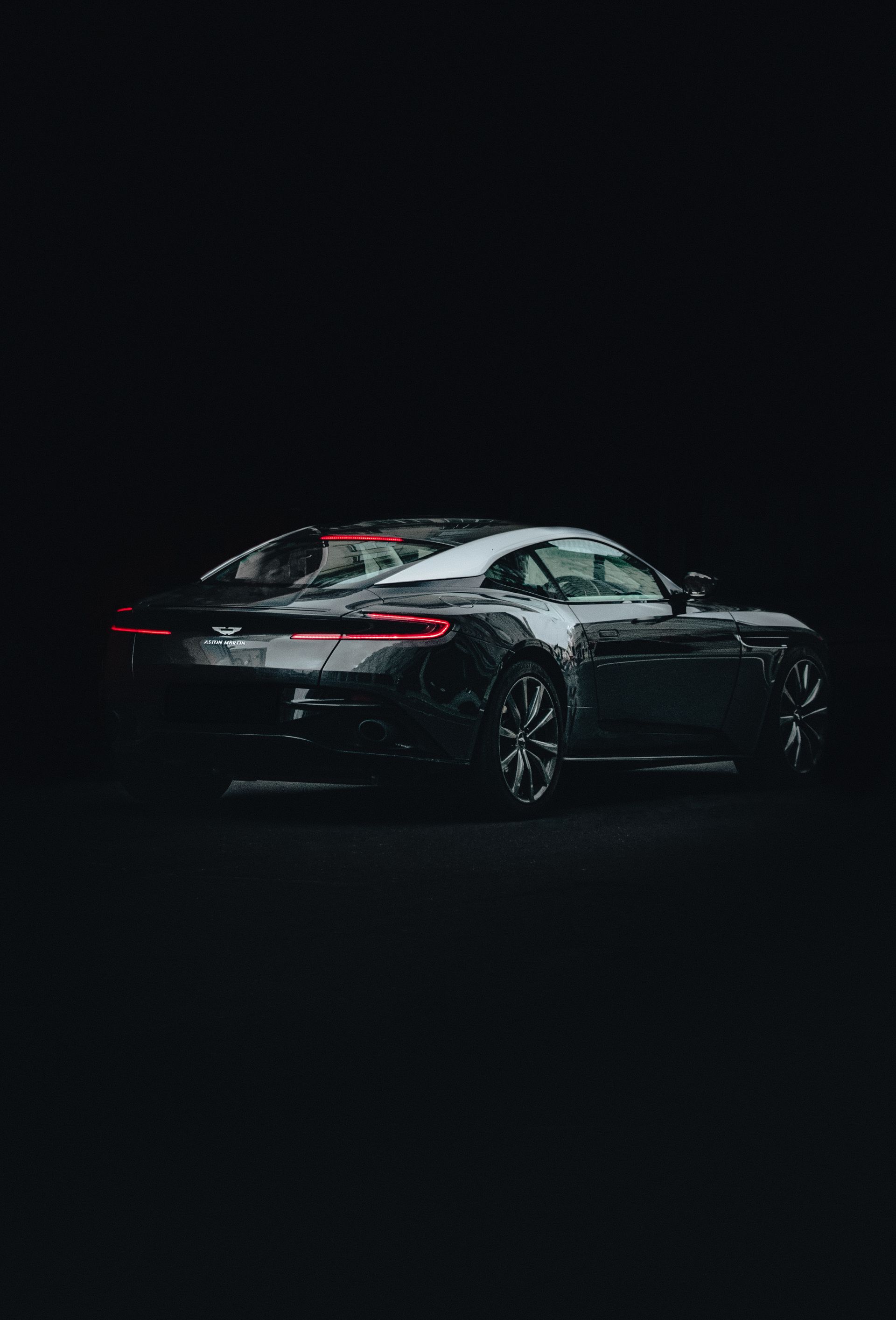 Deep, reflection-clear paint on a dark coupe under studio light