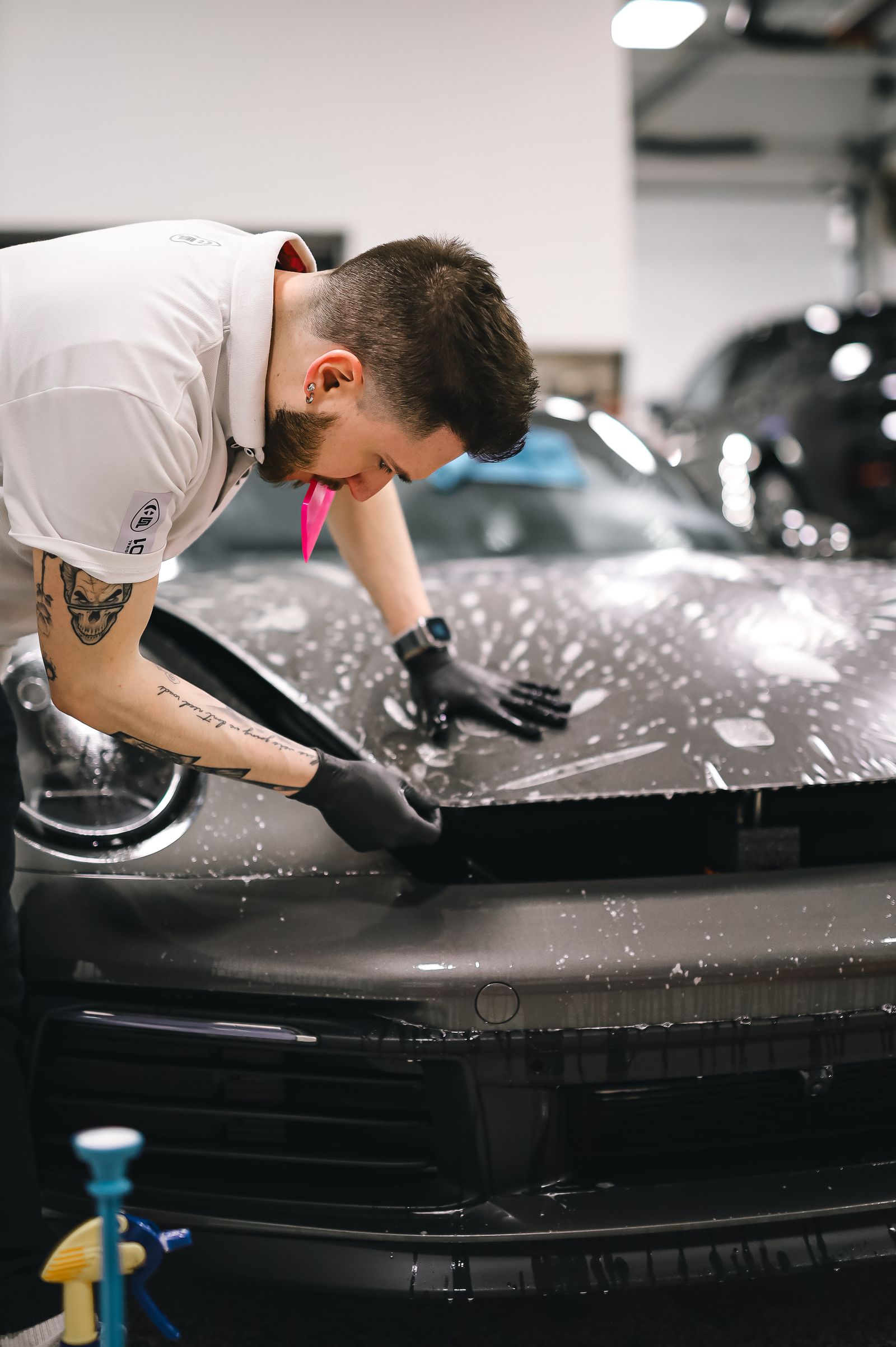 An installer squeegeeing film onto a hood