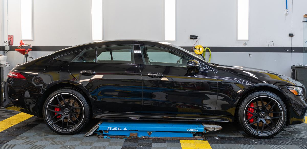 A Mercedes-AMG GT 63 in gloss black, side on in the ACP bay