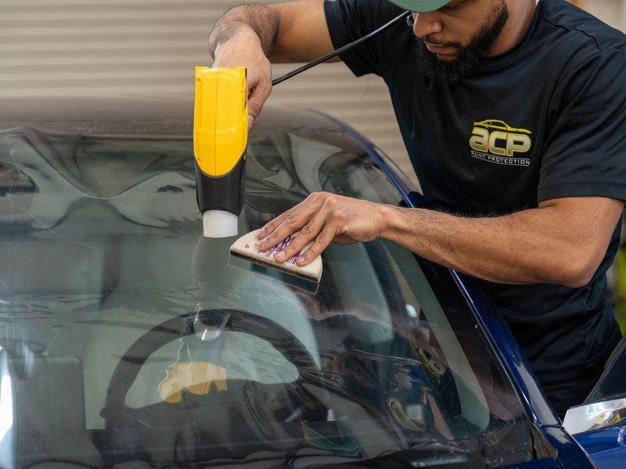 An ACP technician squeegeeing film smooth while heating it